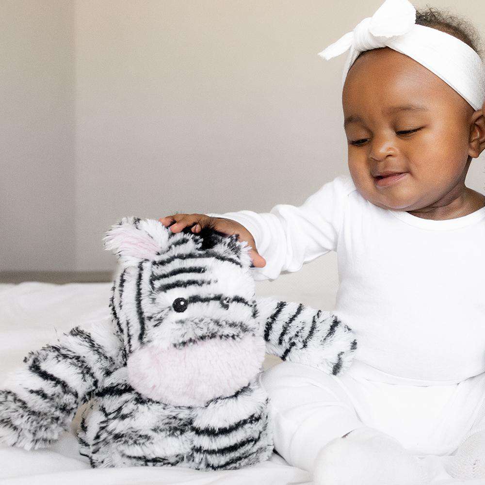 Baby playing with Soft Warm Weighted Zebra Plush Warmies